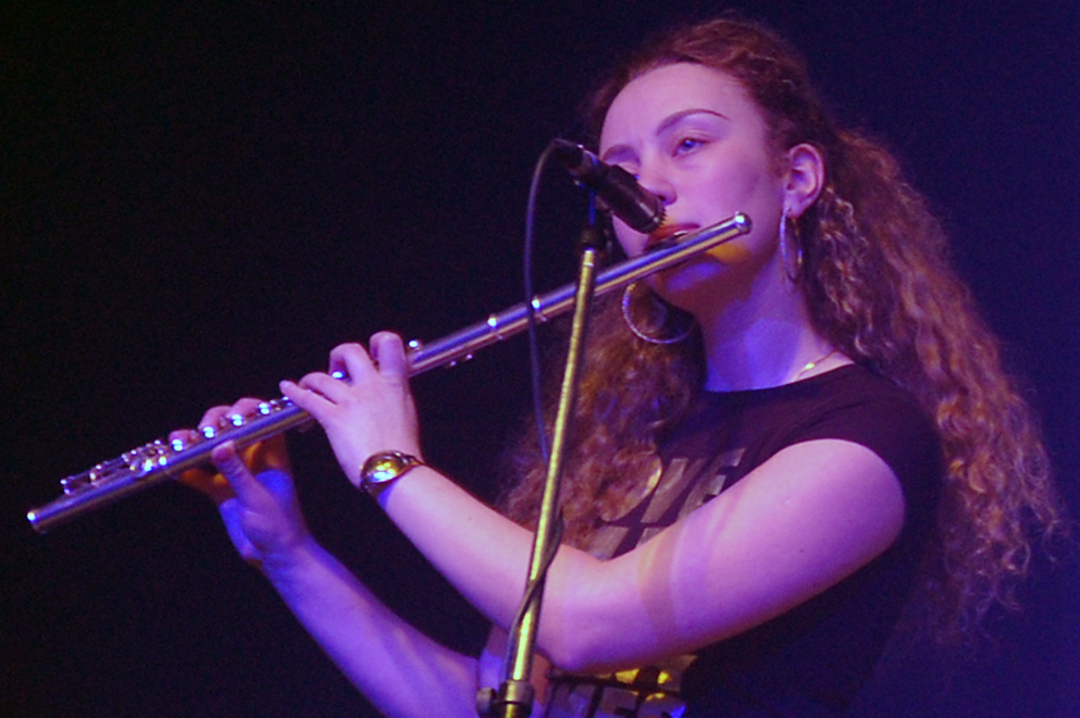 a female with long hair playing a flute