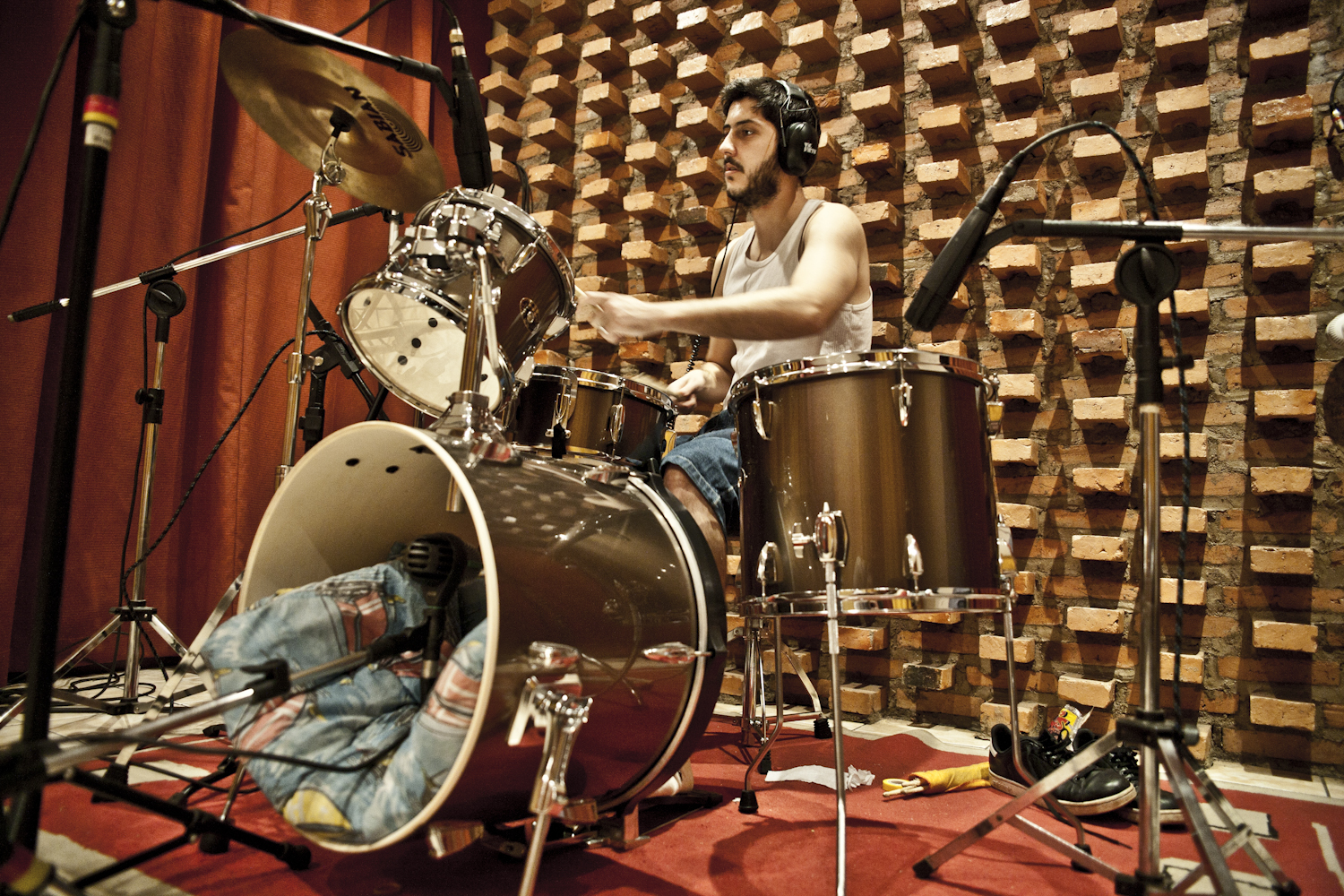 a man playing drums in a room with drum sticks