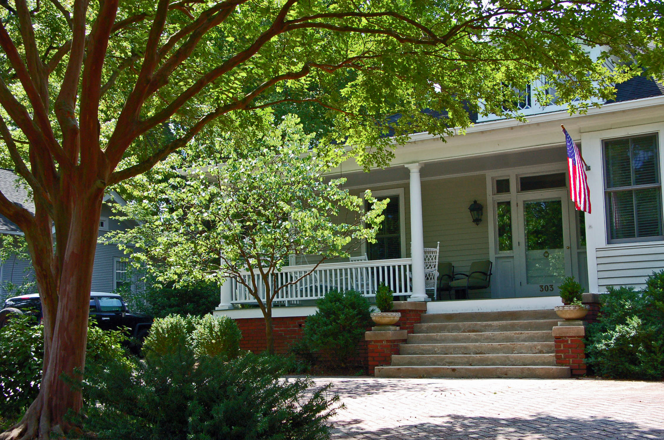 a red brick home with a large tree outside