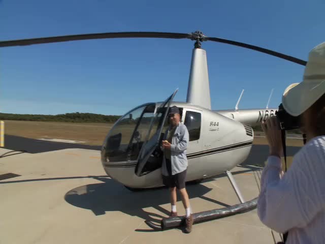 a man with a camera filming a helicopter