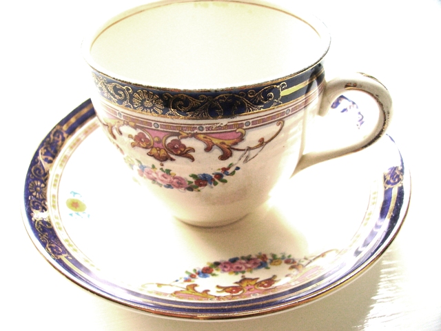 a coffee cup on a saucer with a blue border