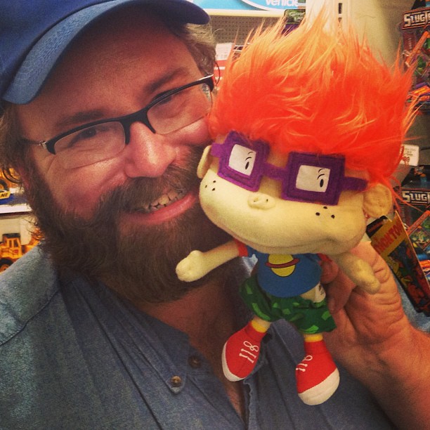 a man with a beard and glasses is holding a toy