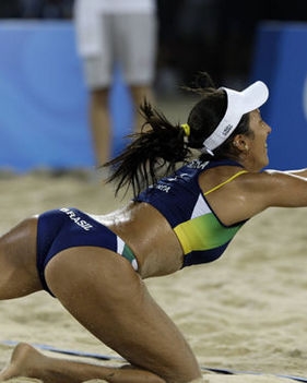 a woman is on the sand playing volleyball