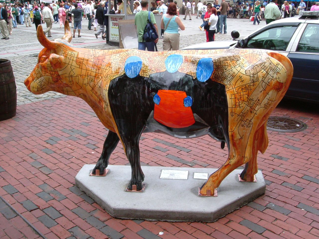 a statue of a cow on a city street