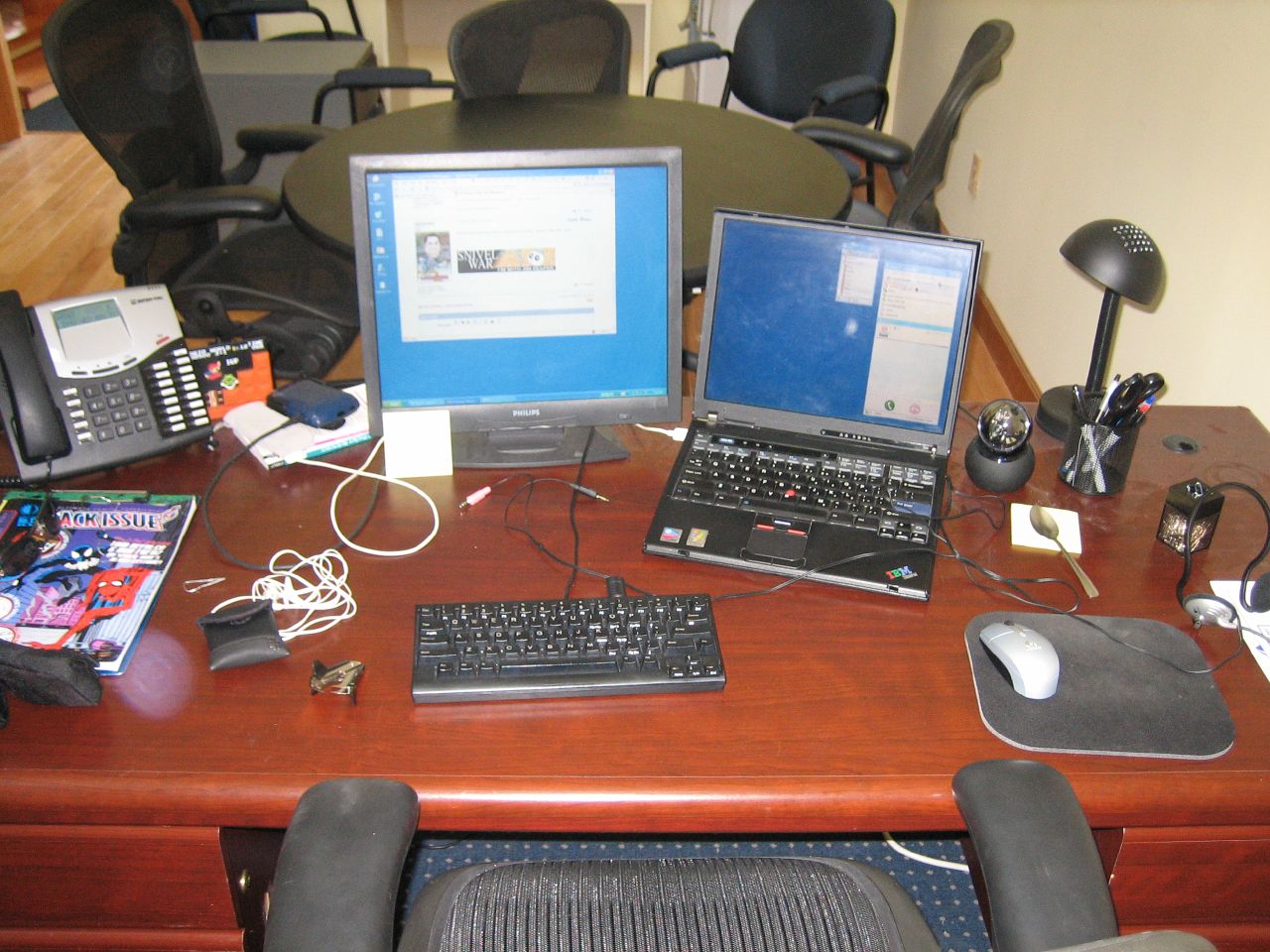 there is a laptop, desktop computer and desktop phone on this desk