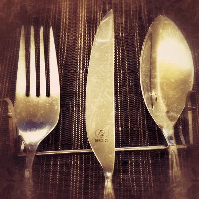 three forks and spoons are sitting side by side on a table