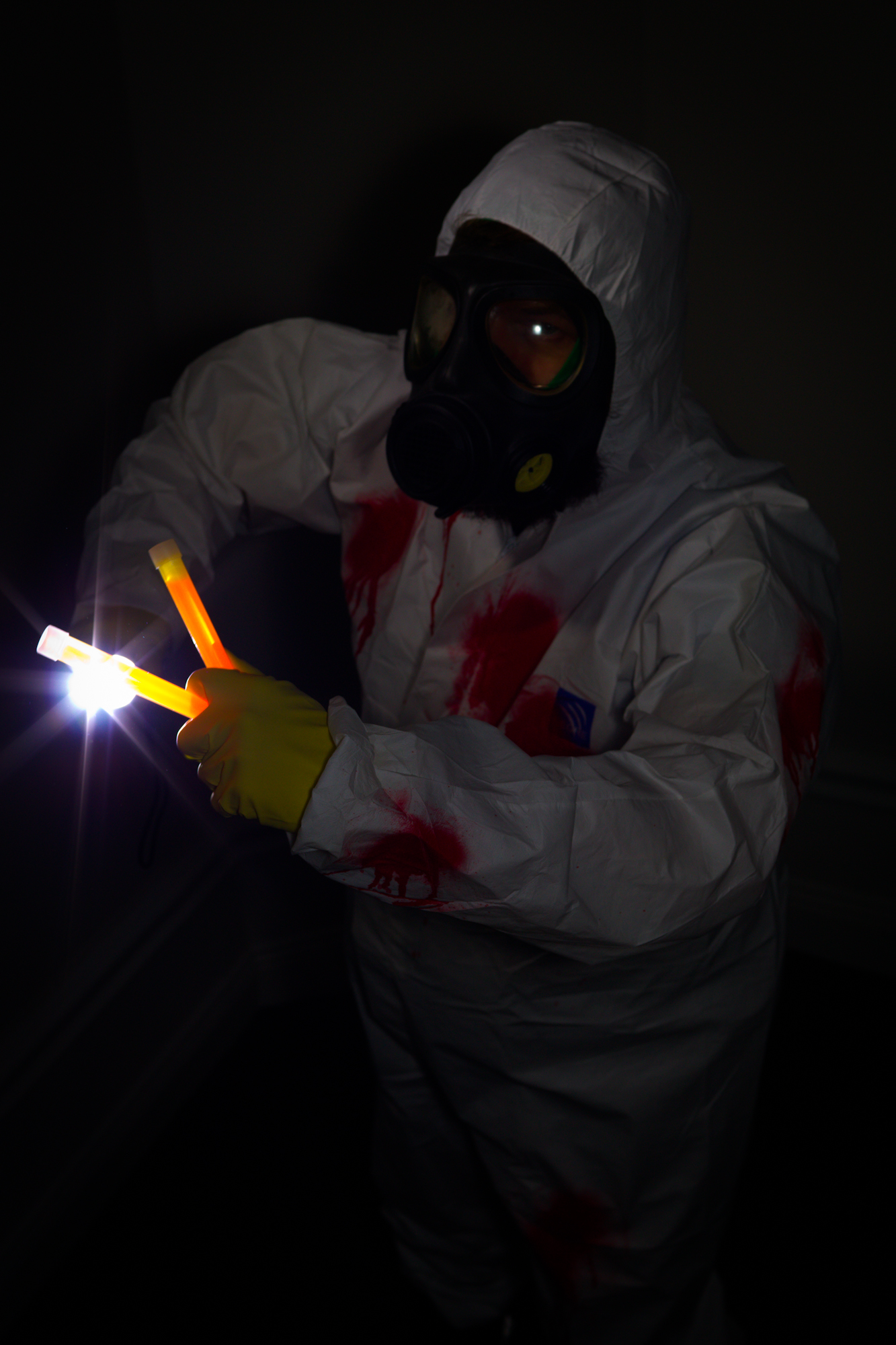 a man in a white and red suit and protective face mask holds the light from a lighter