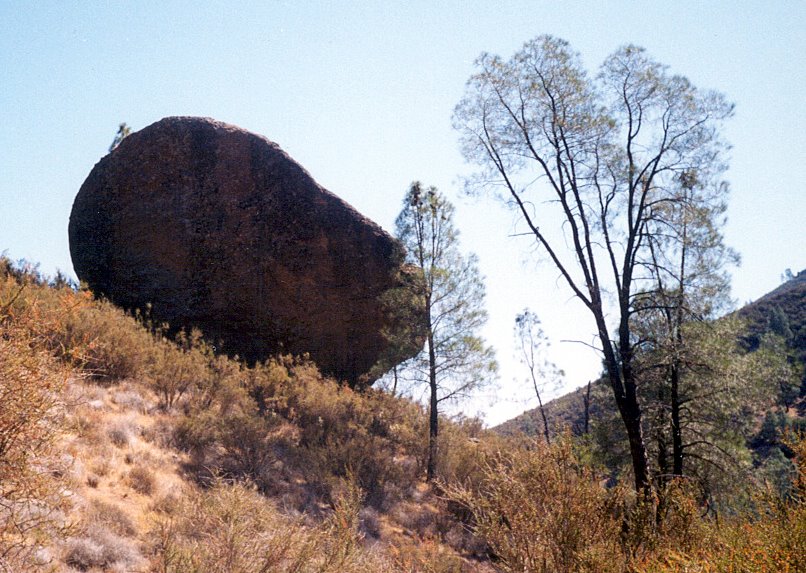 a large rock on the side of a hill