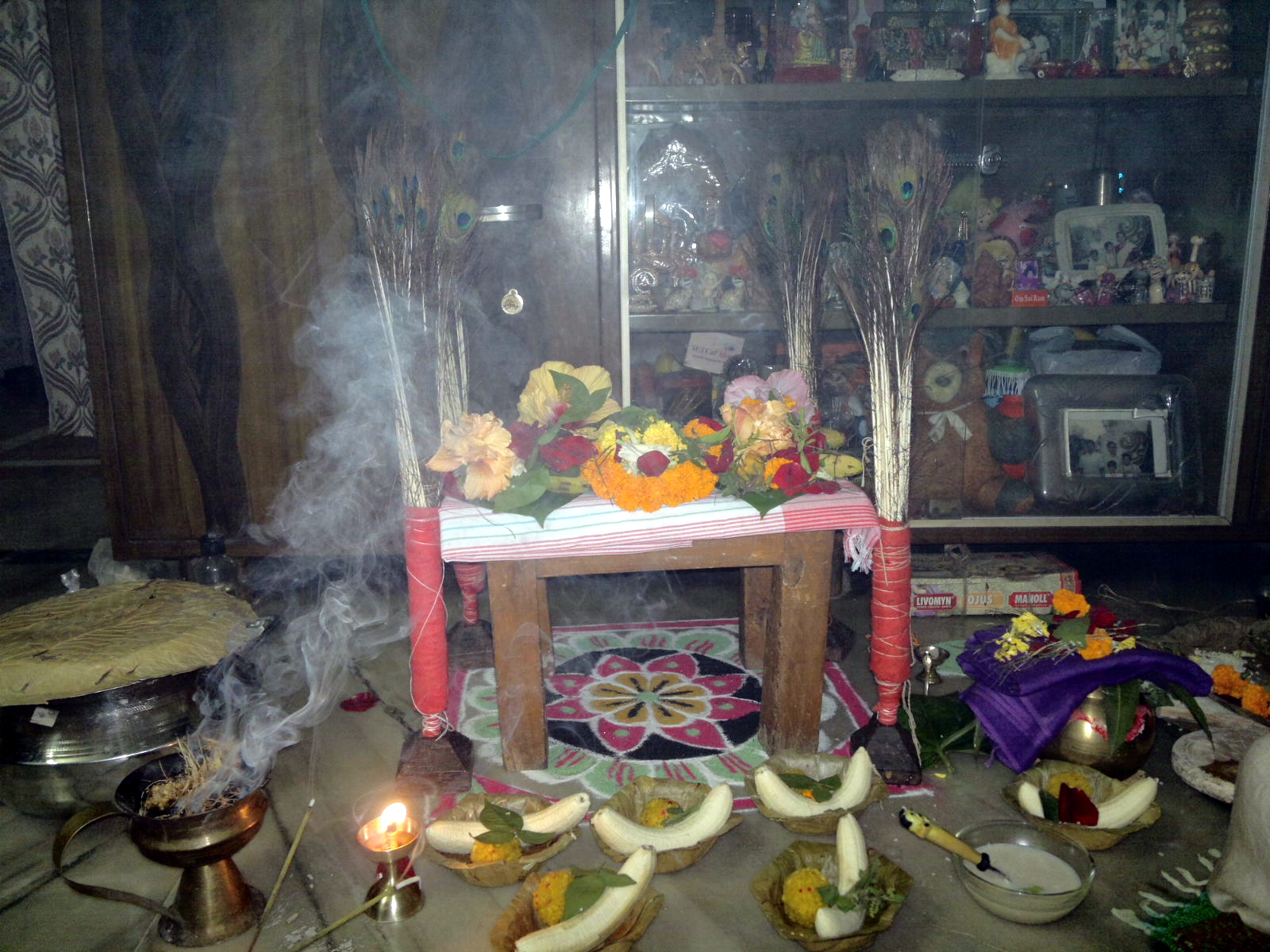 a small shrine setting with flowers and fruit