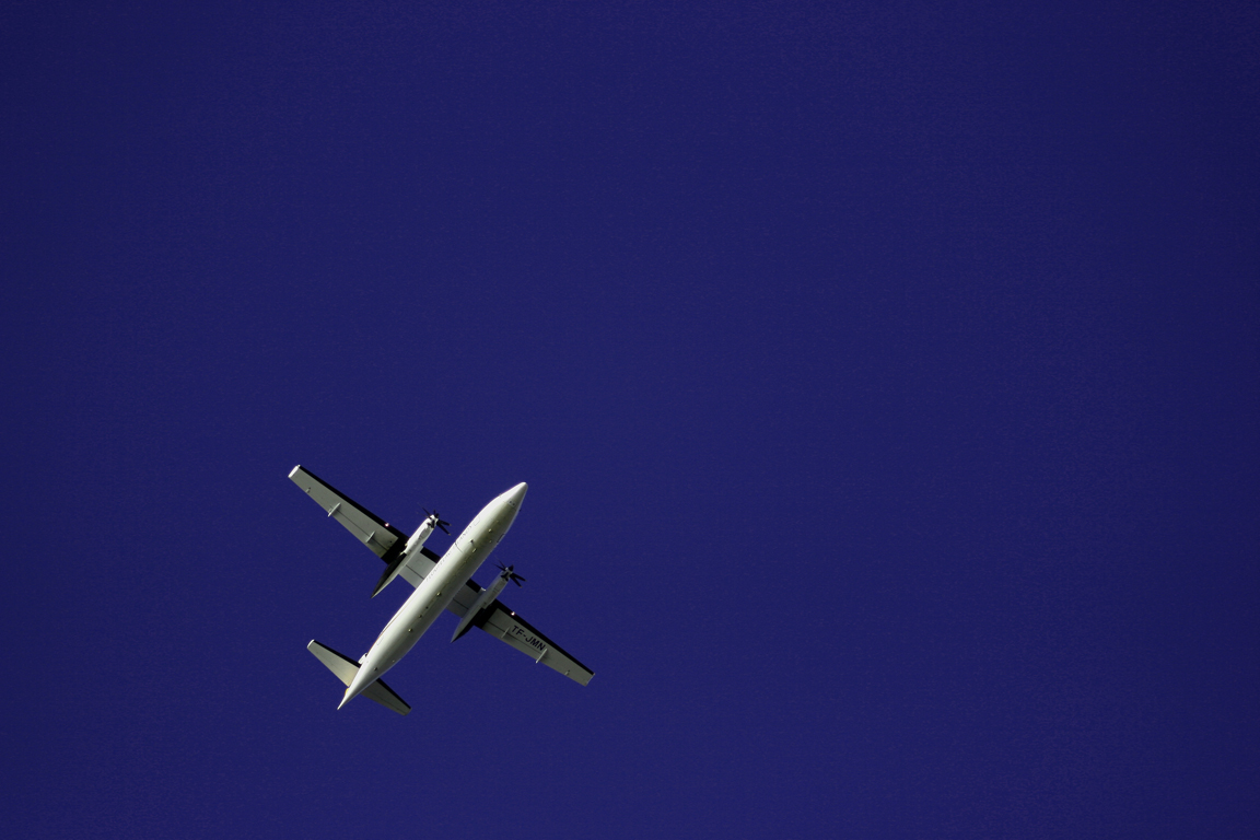 an airplane in the blue sky with its landing gear down