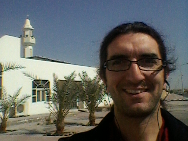 a man is smiling while standing in front of an old church
