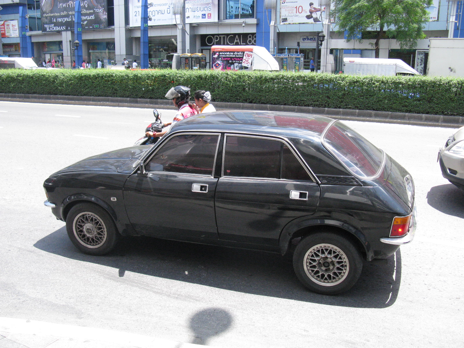 a child in a motorcycle helmet sits on the top of a car