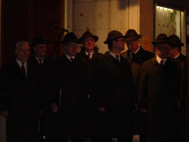 several men are dressed in hats and standing together