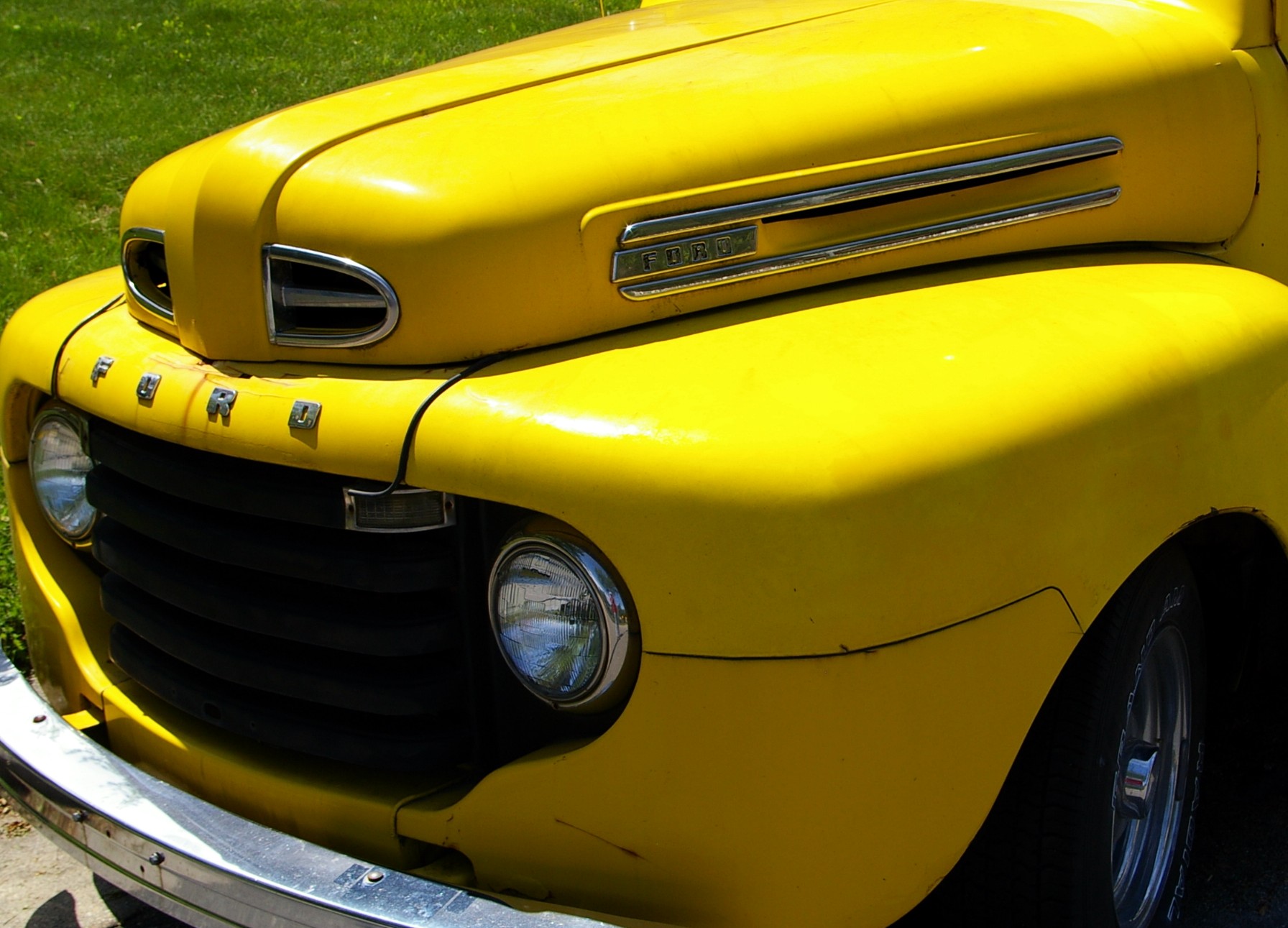 an old yellow truck with shiny chrome lettering