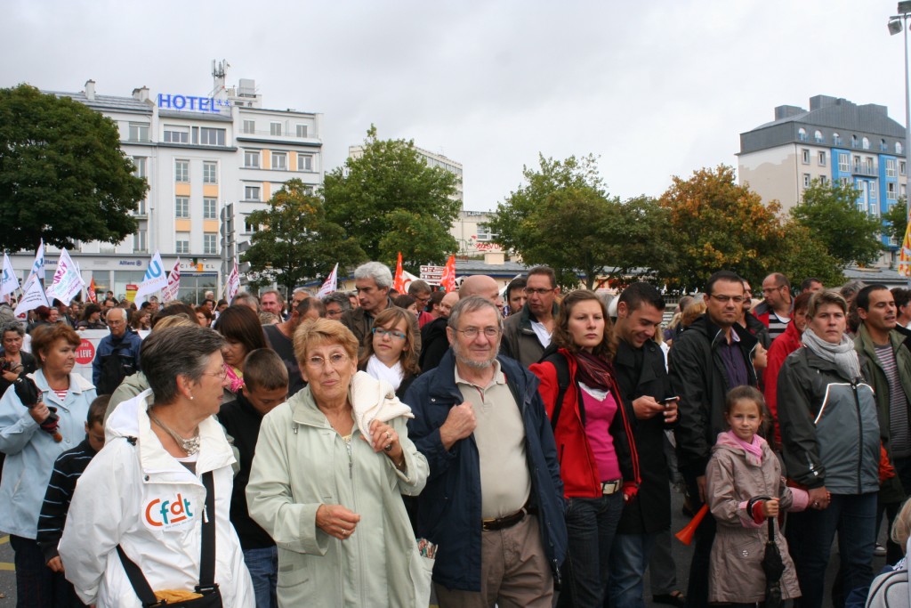 large crowd of people marching through a city