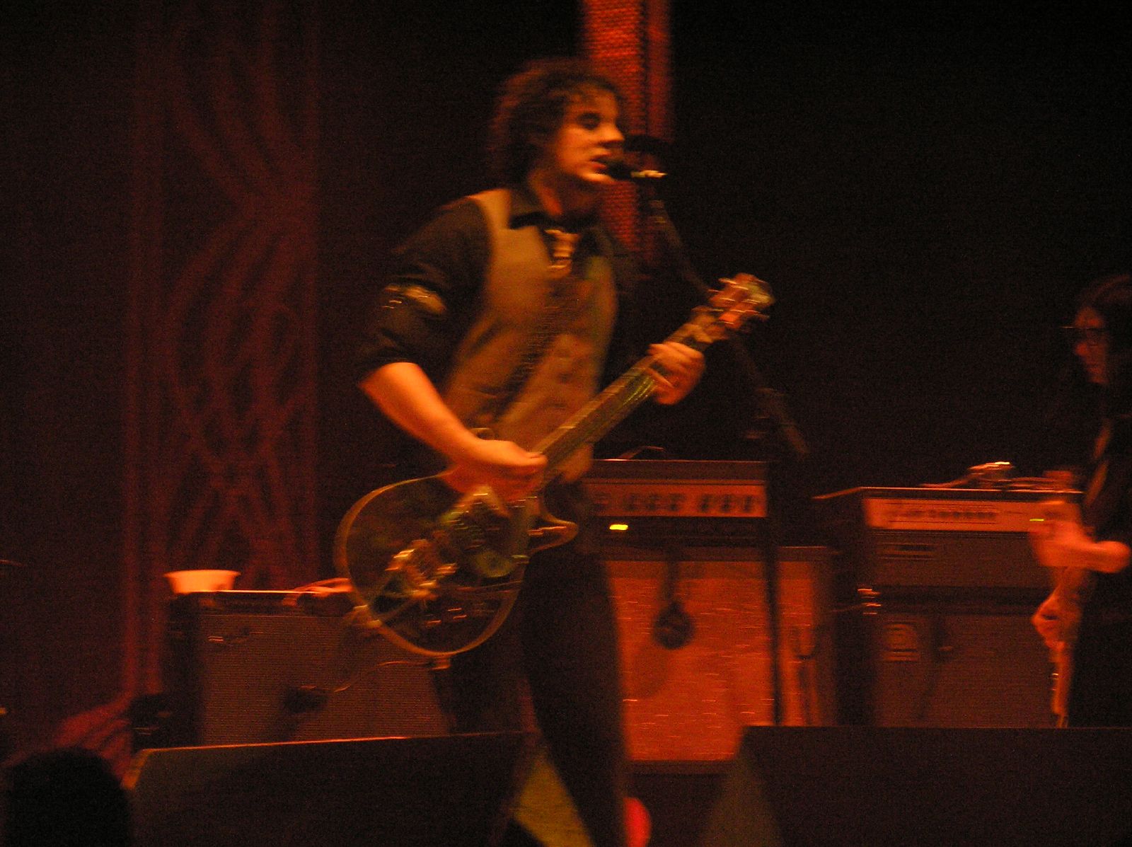 a man is playing a guitar and singing into a microphone