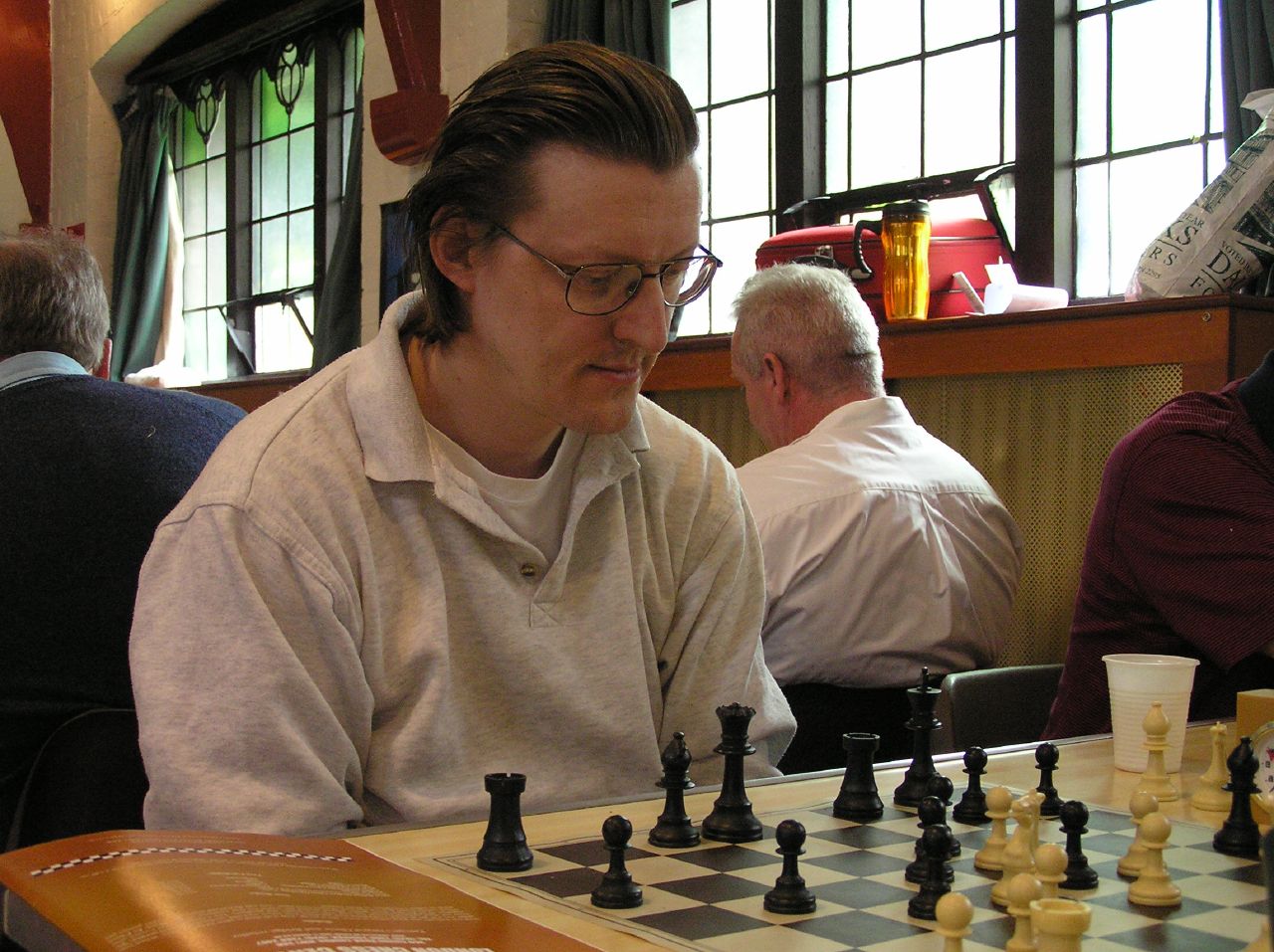 a person playing chess while other play chess