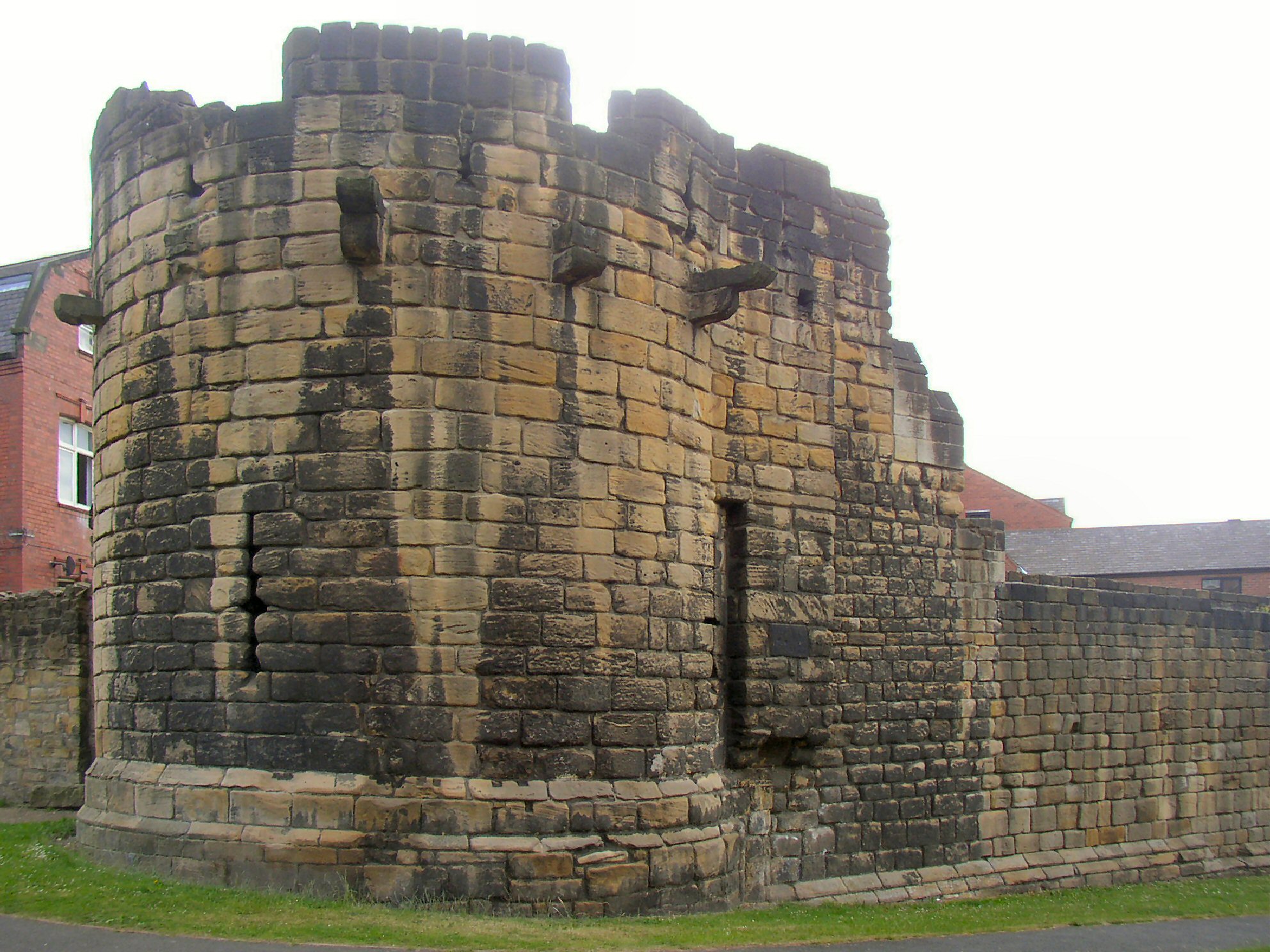 a large brick building with grass near by