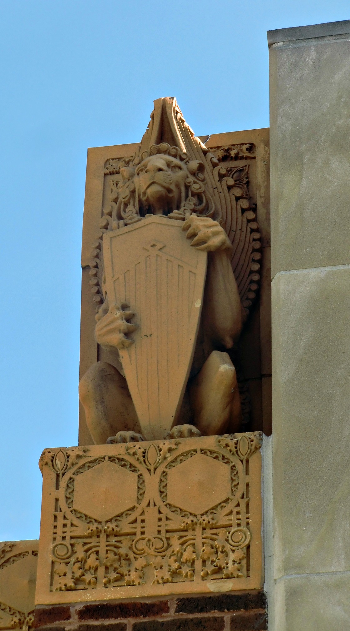 a large brick building with a statue of a harp player holding a shield