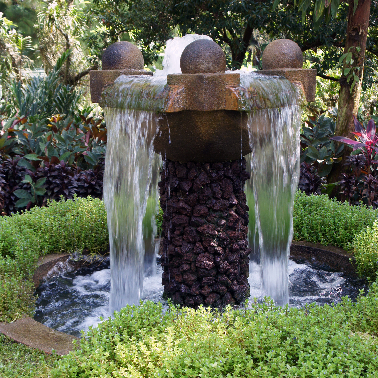 a water fountain with multiple water features in the center of it