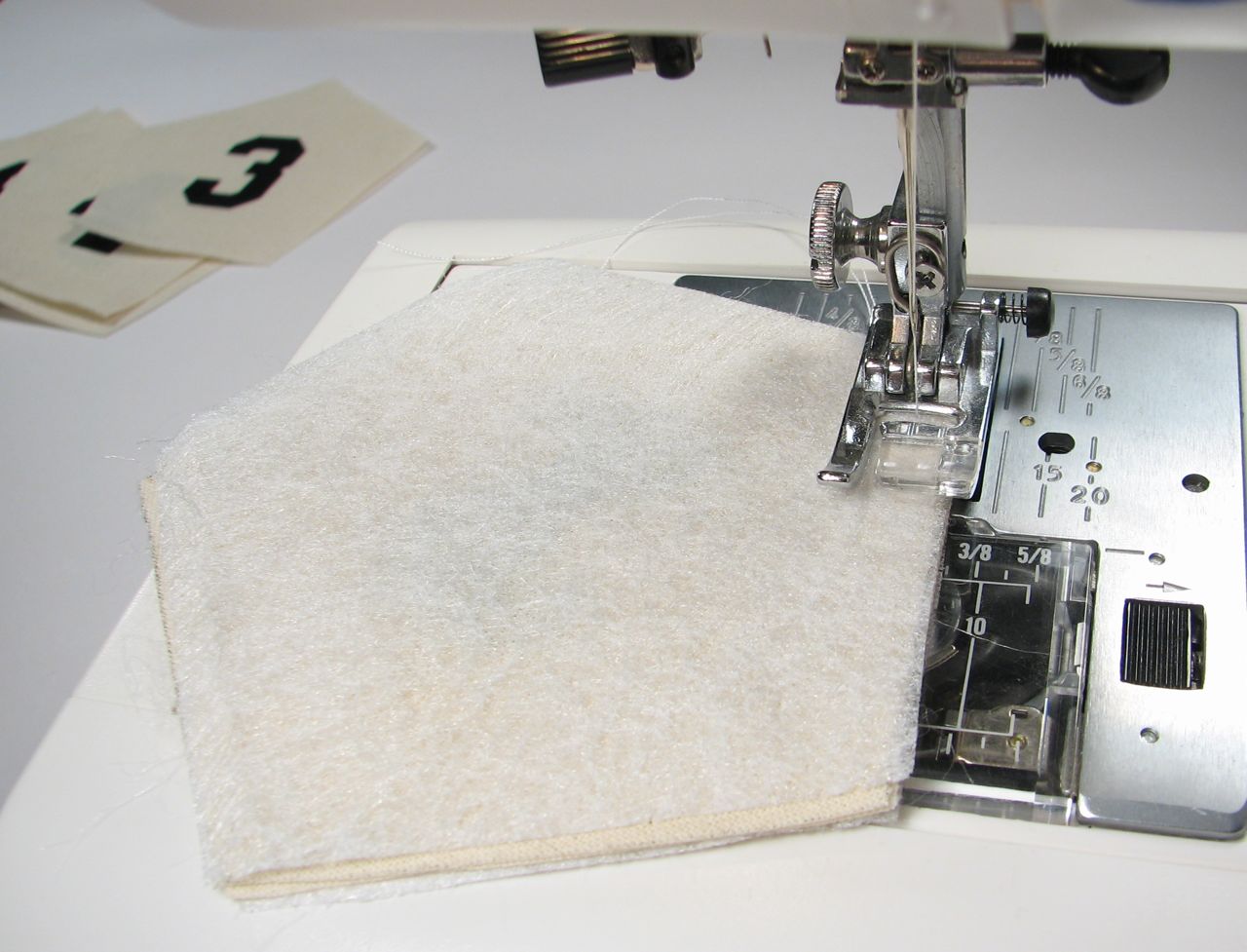 an up close image of a sewing machine with two needle holes