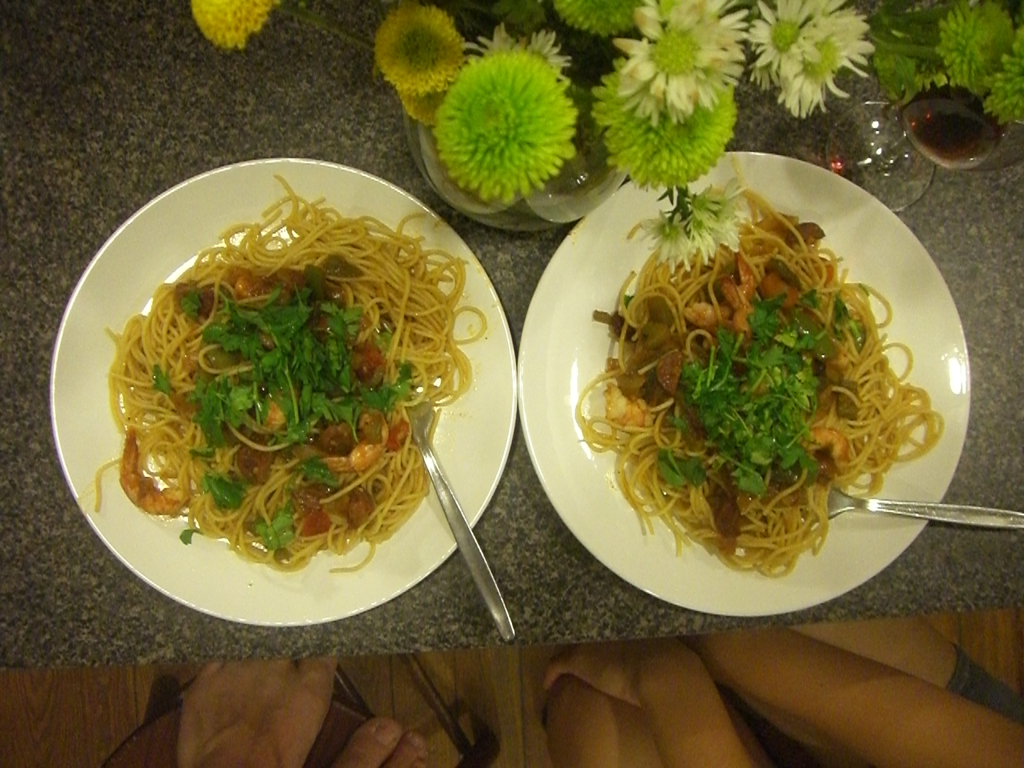 two plates of spaghetti, and a vase with flowers