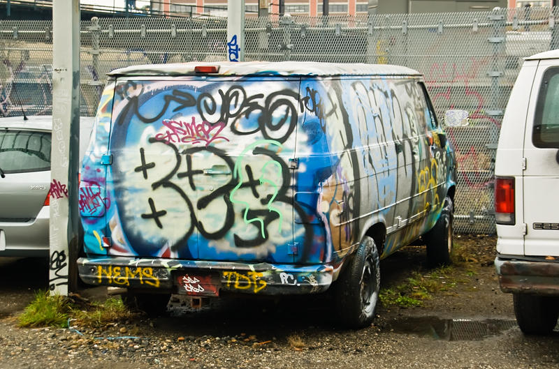 a van that is covered with graffiti and spray painted words