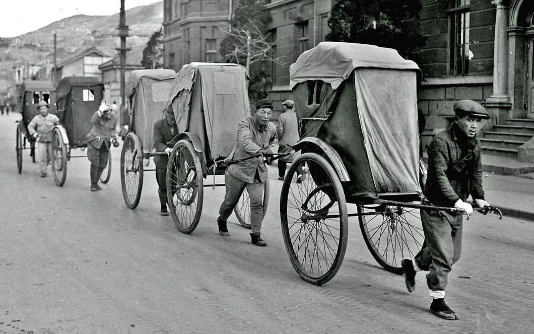 a vintage black and white po shows a line of people riding bicycles