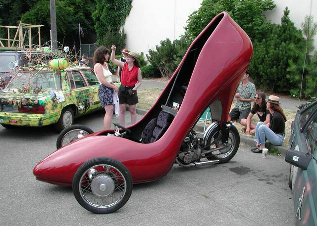 a strange looking shoe with two ladies taking pictures