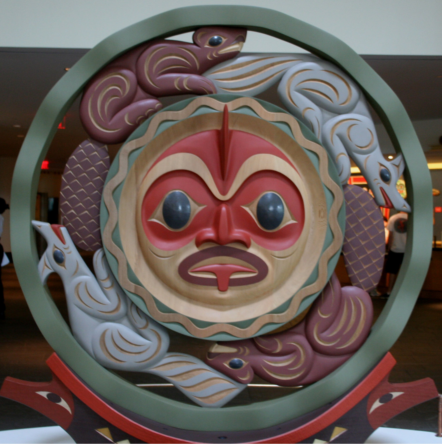 a colorful mask is displayed in front of a round object