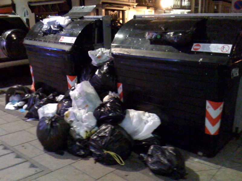 large amount of garbage being piled up on the side of the road