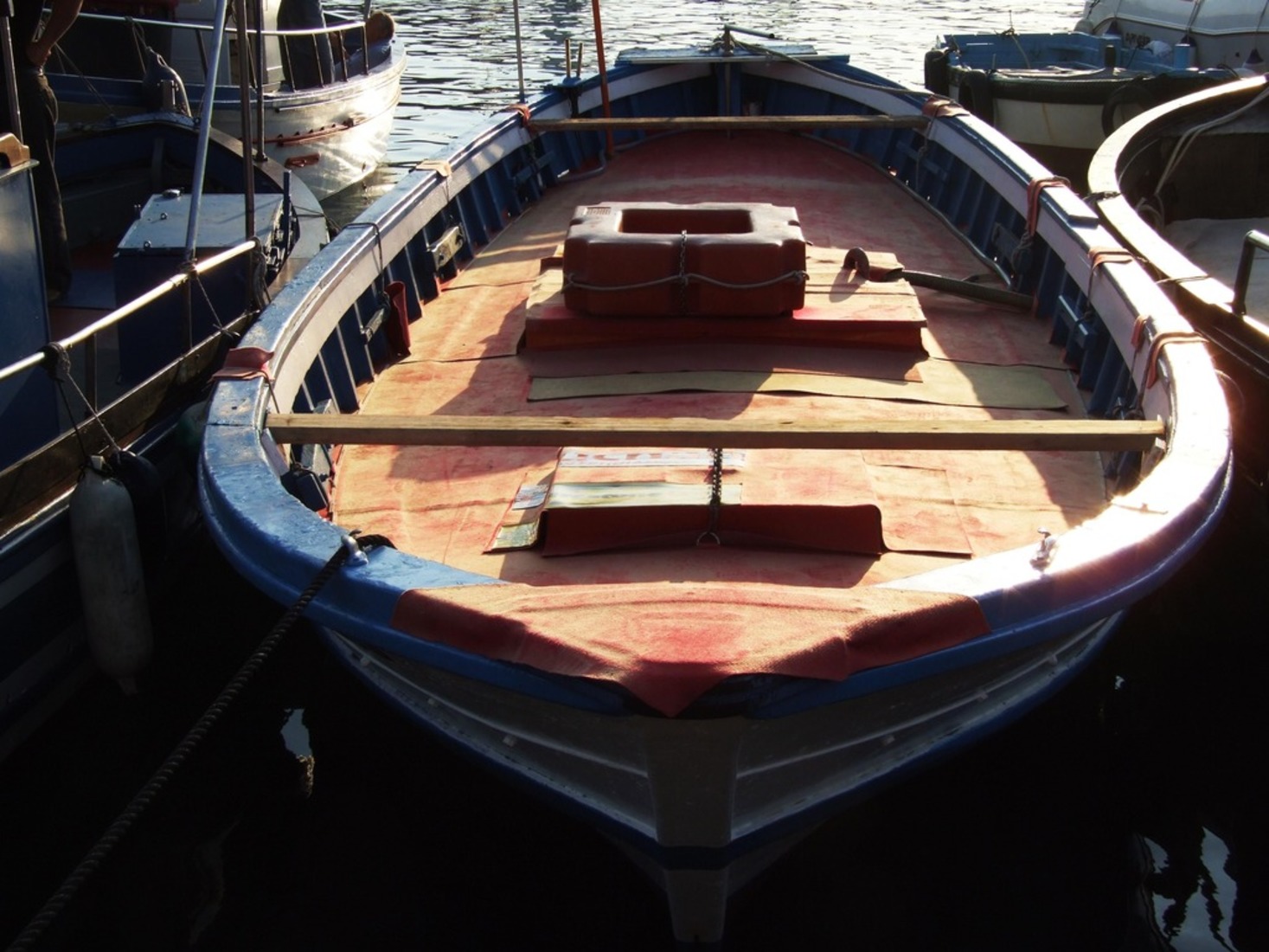the empty wooden boat docked is ready to be picked