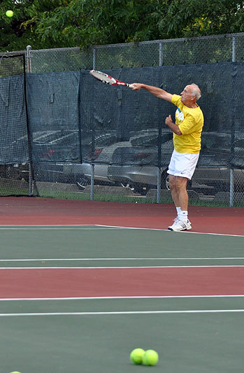 an old man on the court swinging his racket