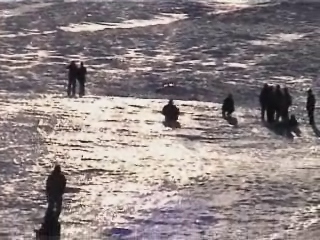 many people walking out into the ocean together