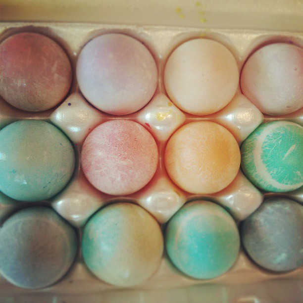colorful eggs with their colored tops in a box