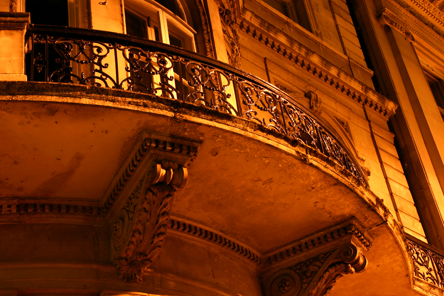 a wrought iron balcony and railing on an old building