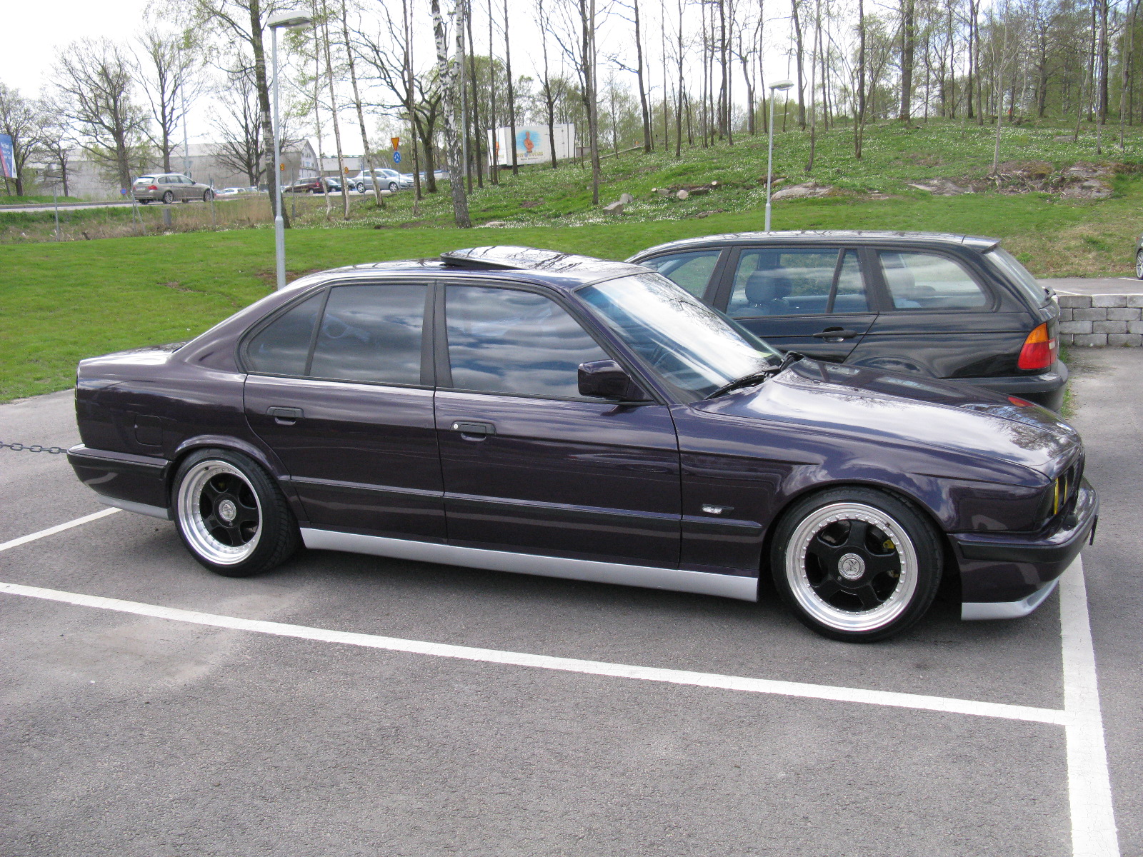 a grey bmw is parked in a parking lot