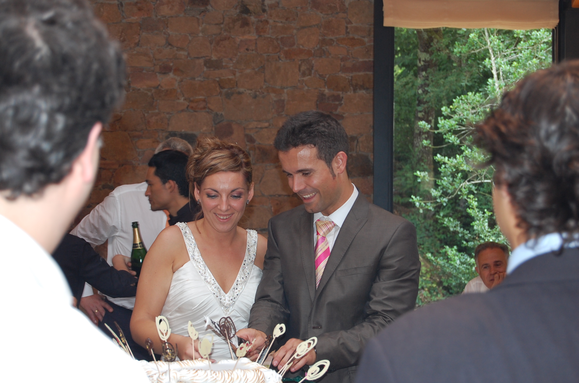 a couple  their wedding cake in front of others