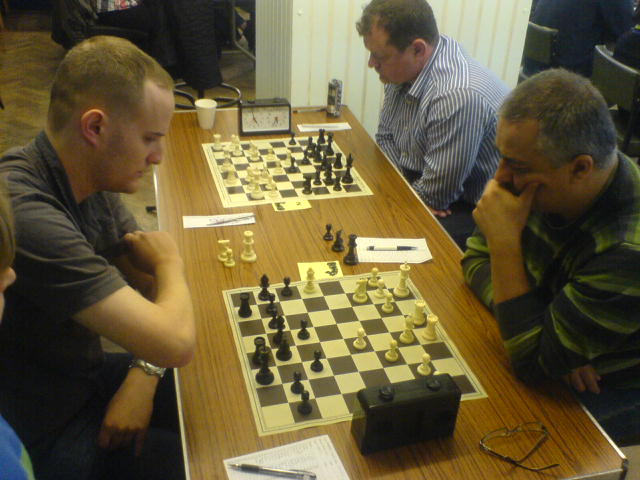 people play chess on the wooden board