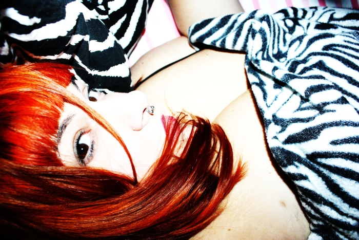 a woman with red hair is laying in bed