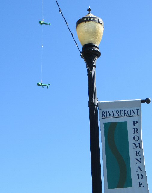 a street lamp and green birds in the air