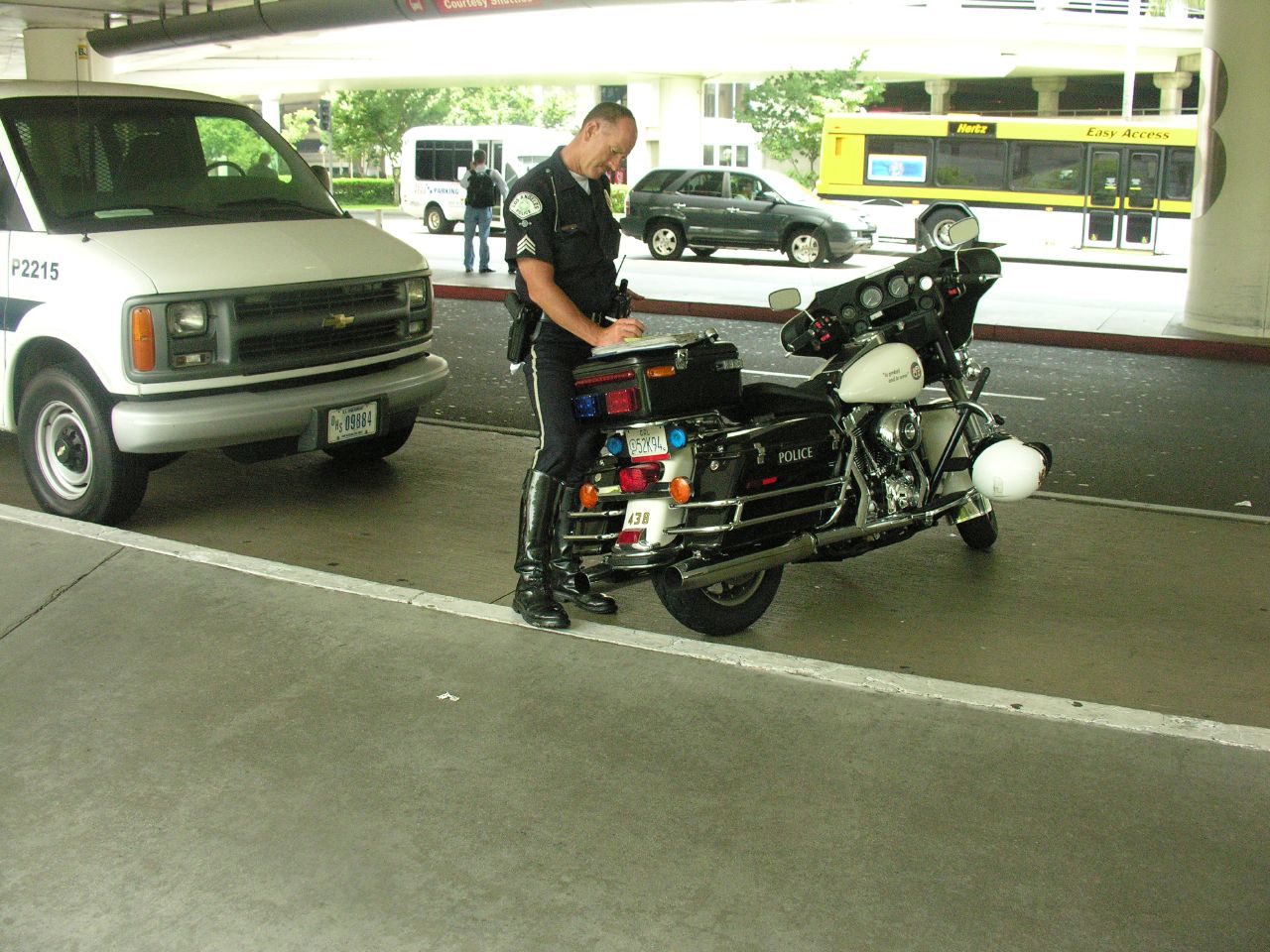 a cop standing next to a parked motorcycle