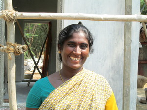 a woman with a colorful sari smiles for the camera