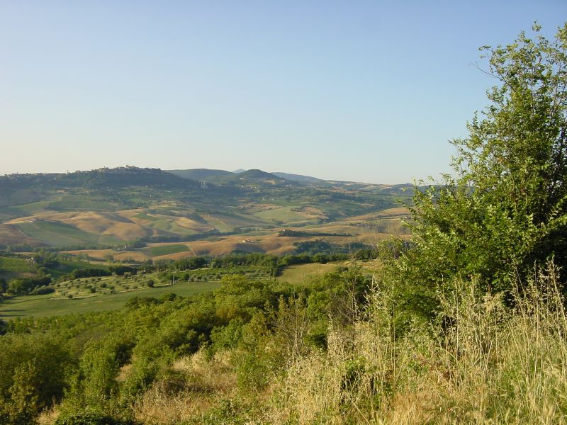 a hill on the side of a valley with rolling hills in the distance