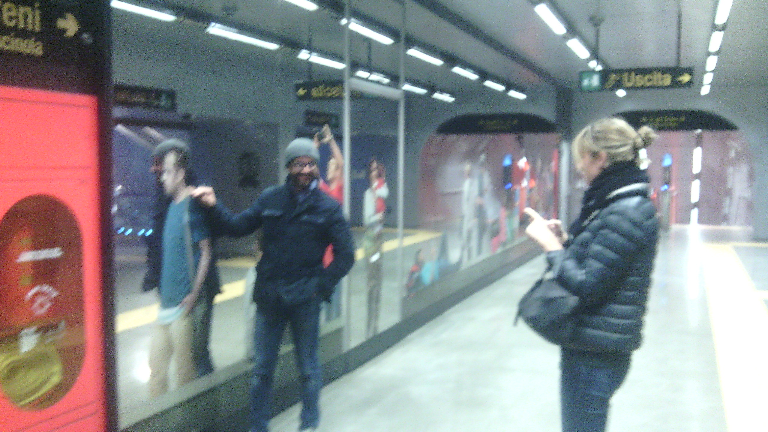 a woman and man standing in the reflection of the train