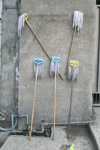 there are brooms and mops next to the curb