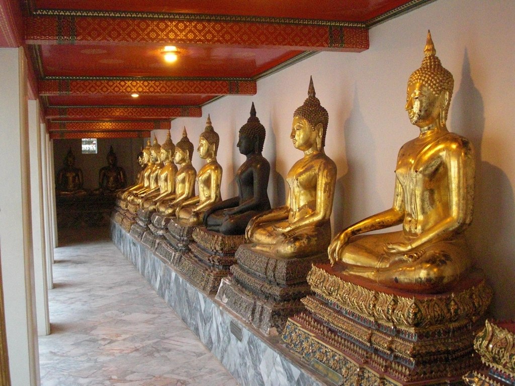 the golden statues are sitting behind a wall
