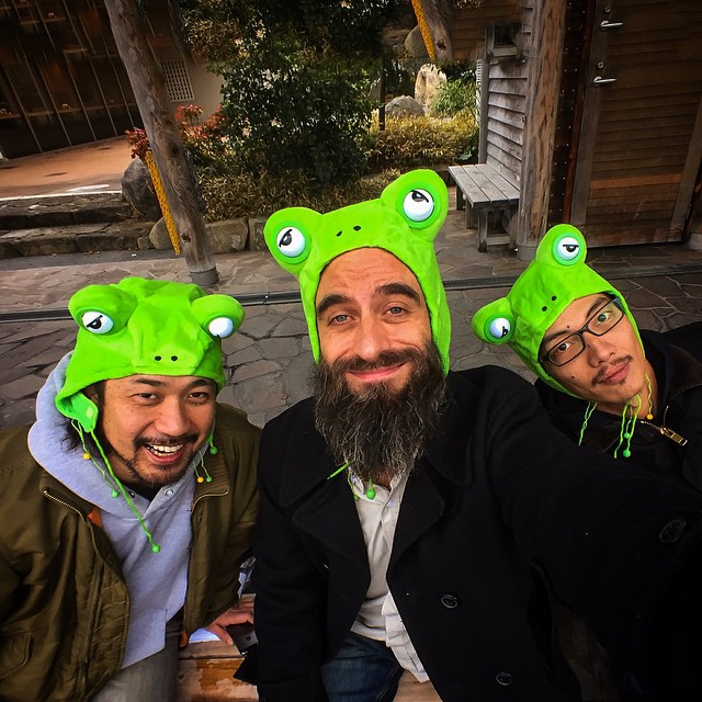 three men sitting down with funny hats on