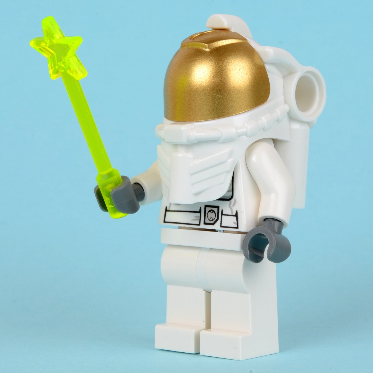 a toy is holding a gold ball and a green laser light
