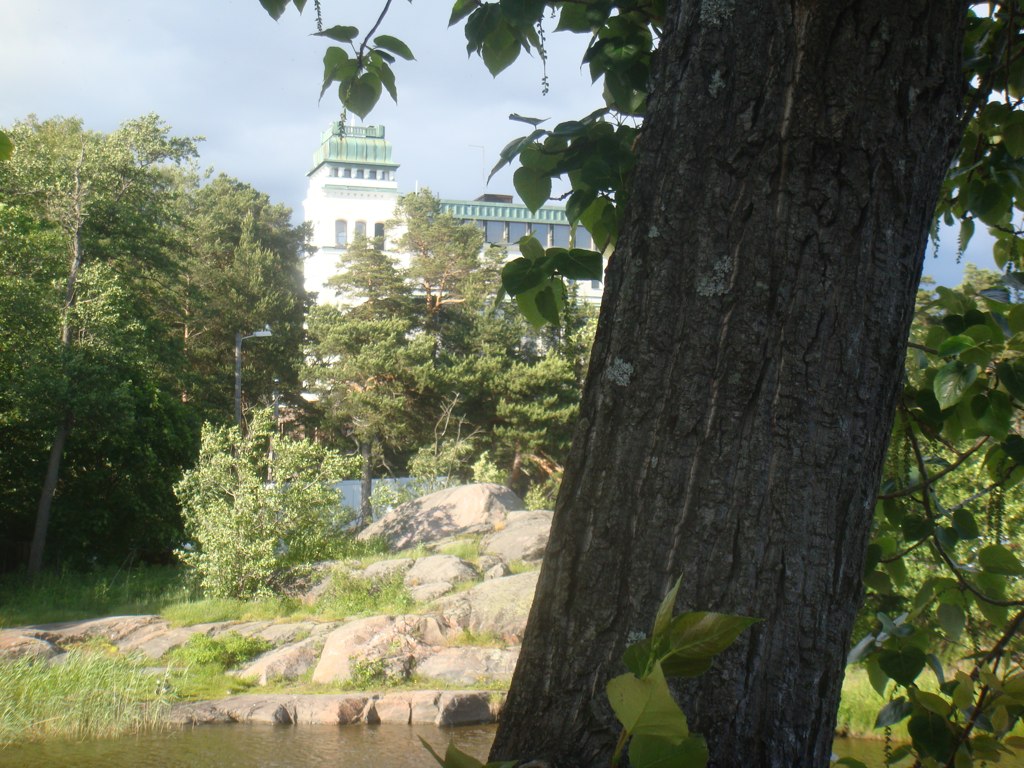 a building with a green dome next to trees